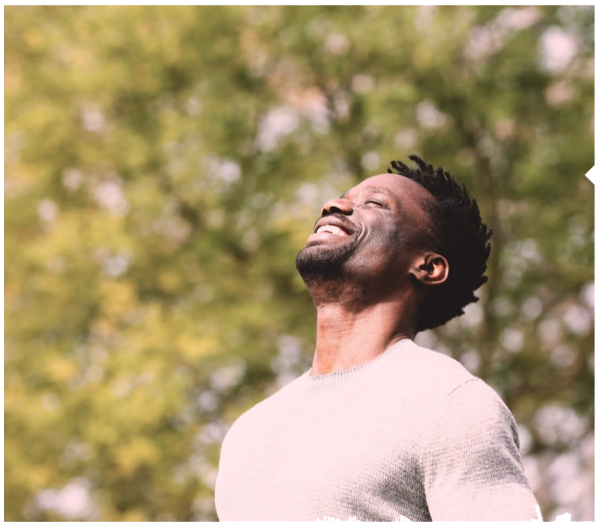 Man enjoying fresh air outdoors with eyes closed.