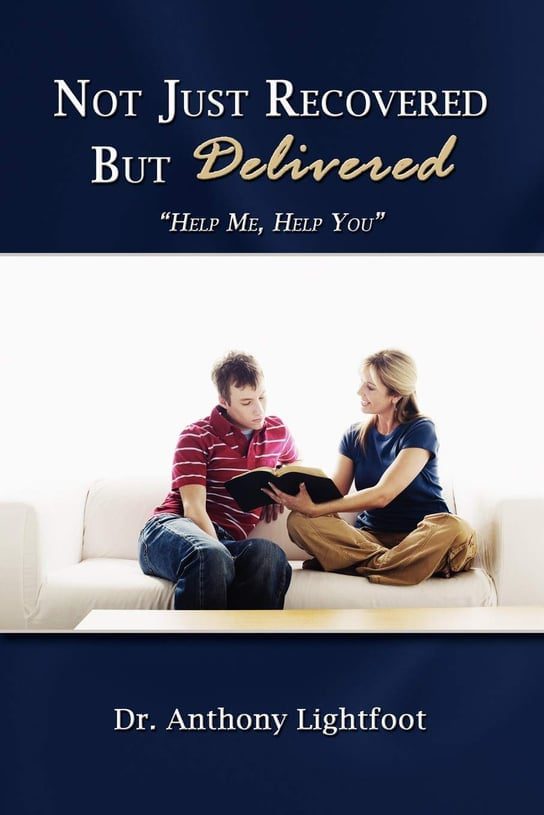 A couple sits on a couch holding a Bible, hopeful and engaged.